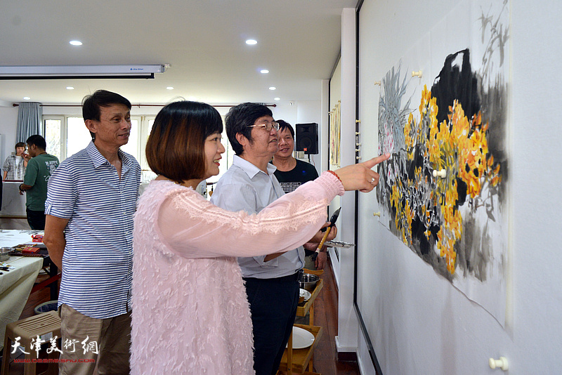 张帆与书画家王惠民、彭英科、李根友欣赏创作的画作。