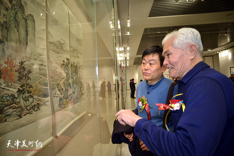 谢玉玺、由国荣观赏展出的何延喆通景屏作品《江山羁旅》。