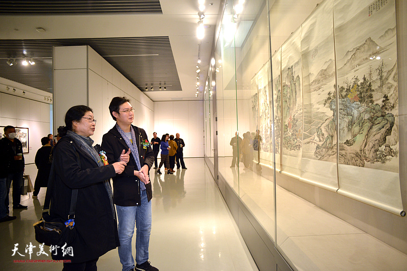 张永敬、王政观赏展出的何延喆通景屏作品《江山羁旅》。