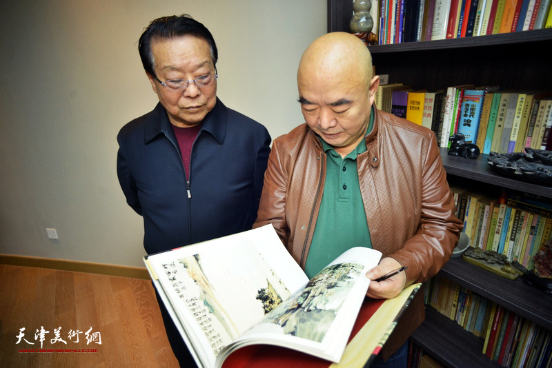 尹沧海、胡玉林阅览唐云来先生的藏书。