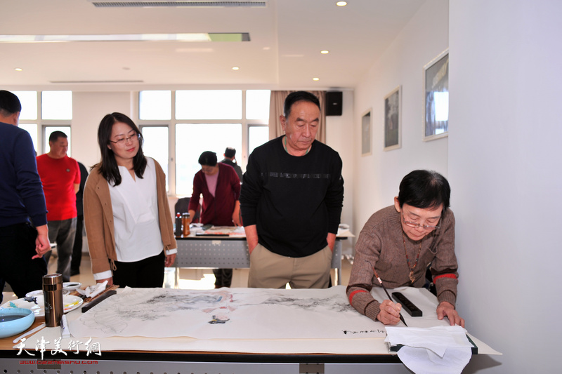 崔永利、李丽华观赏萧慧珠书画创作。