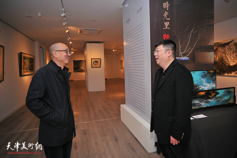 艺术家李博隽与天津美术馆馆长马驰在画展现场交谈。