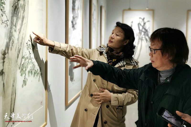董振涛向万镜明介绍展出的作品。