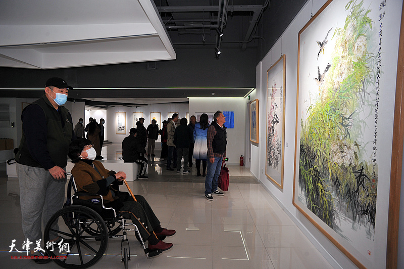 王雪溪在画展现场观赏画作。