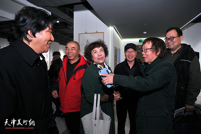 董振涛与庞黎明、王少玉、高学年、史玉、李海波在画展现场交谈。