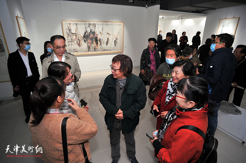 董振涛与来宾在画展现场交谈。