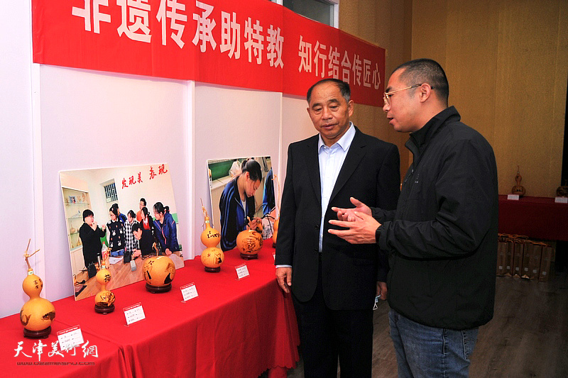 史树海与参展作者在葫芦精品展现场观赏展品。