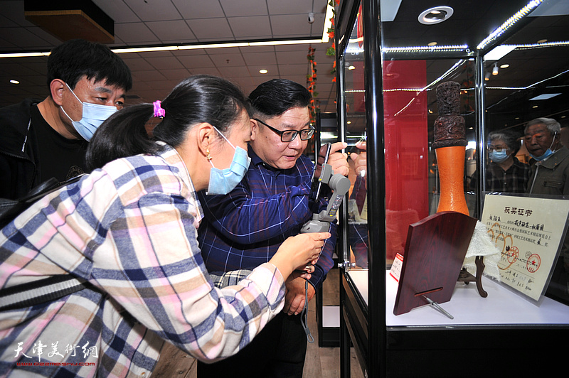 张福来在葫芦精品展现场为观众介绍展出的作品。