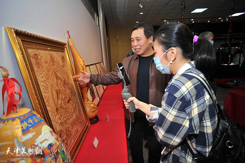 张嘉松在葫芦精品展现场为观众介绍展出的作品。