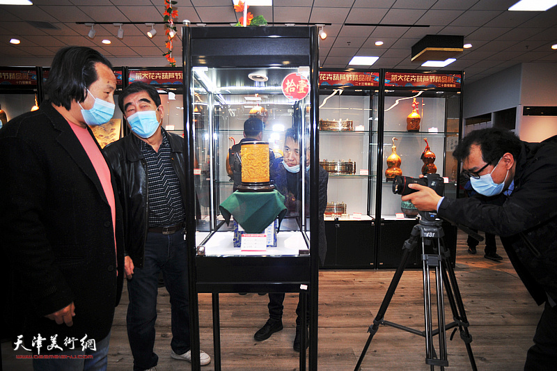 陈文军、张明辉在葫芦精品展现场观赏展品。