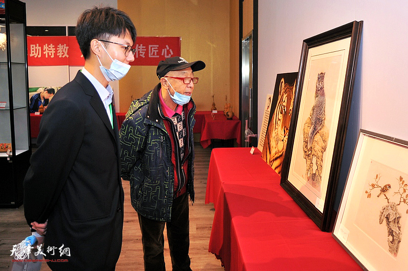 康万生在葫芦精品展现场观赏展品。