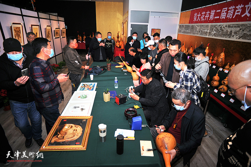 荣大花卉第二届葫芦文化艺术节现场的葫芦烙画技艺交流。
