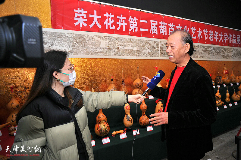 李新明在荣大花卉葫芦文化节现场接受采访。