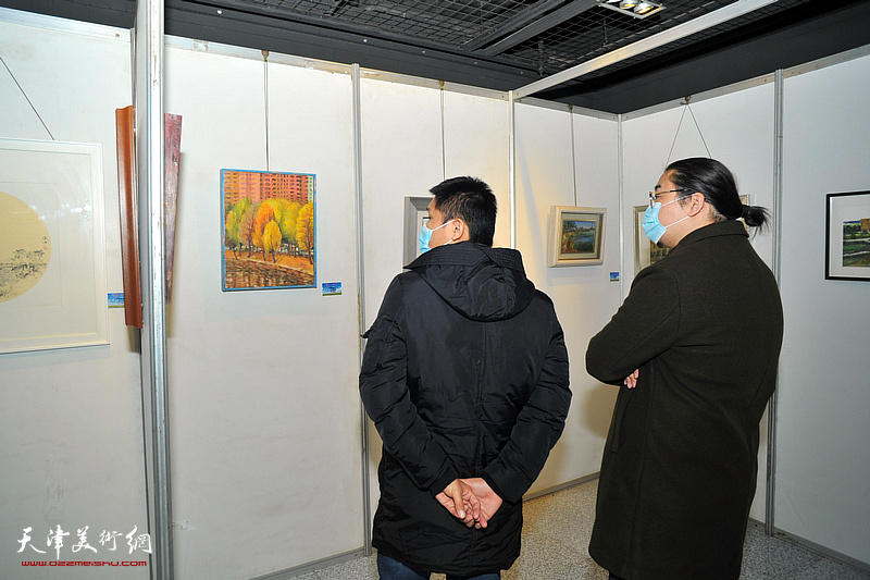 尤翔、郑伟观赏“绿色屏障采风写生作品展”作品。