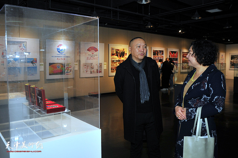 薛明、薛艳在展览现场交流。