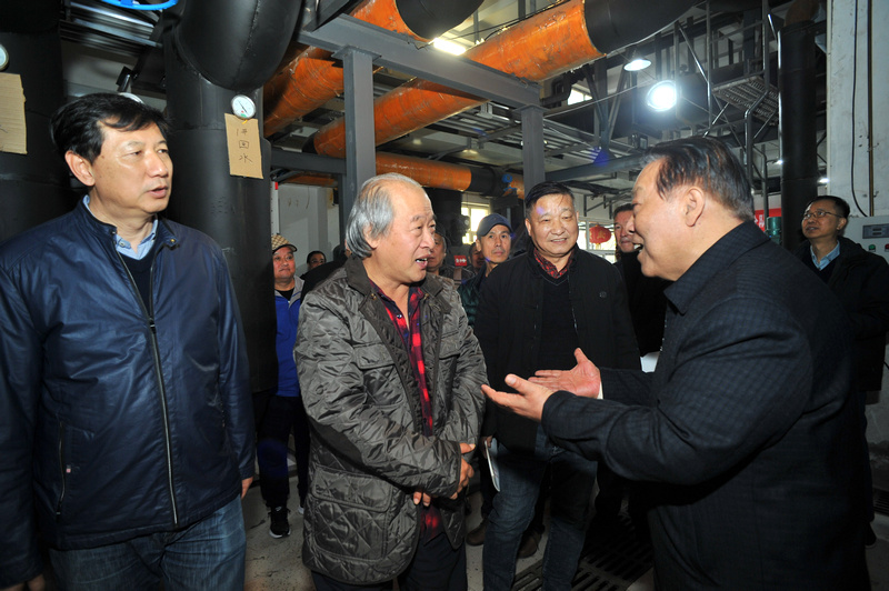 胡玉林董事长向王书平主席等艺术家介绍企业现代化的供热设备。