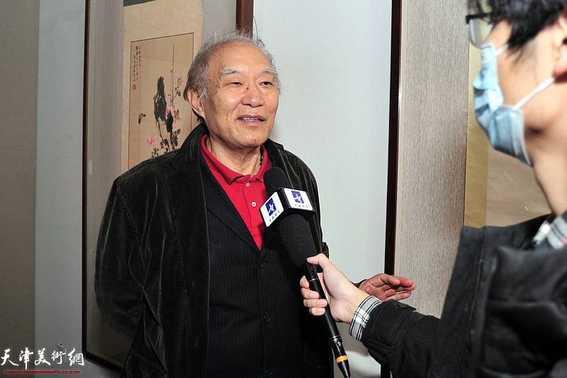 何延喆在画展现场接受媒体采访。