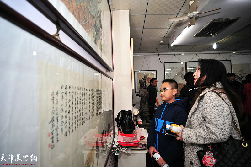 观众在迎新年“姚家班”紫芥园艺术馆书画展上观赏作品。