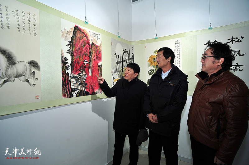 穆怀安、高原春、徐庆荣观赏展出的作品。