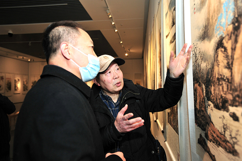 邬海清、郑龙起观赏展出的作品。