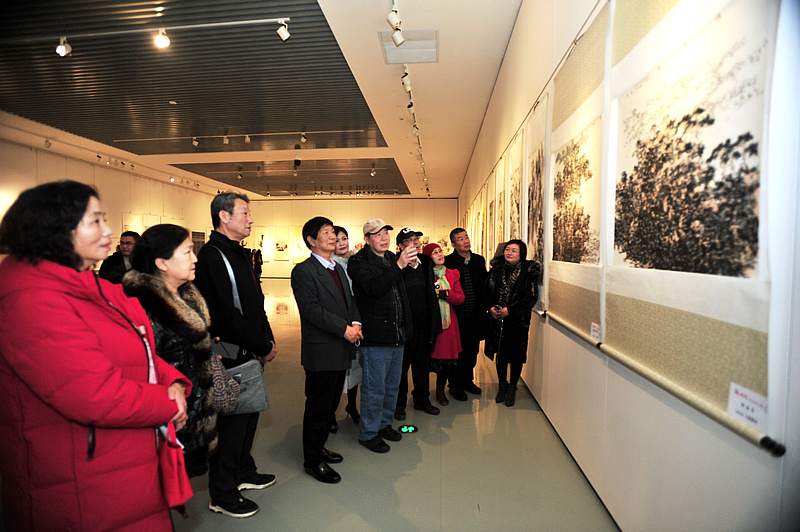 邬海青、李守玉与书画爱好者们观赏展出的作品。