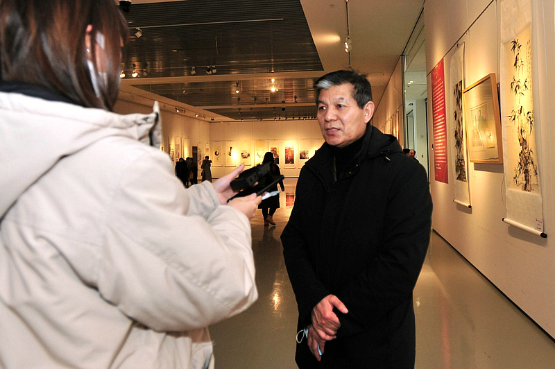 范扬在展览现场接受媒体采访。