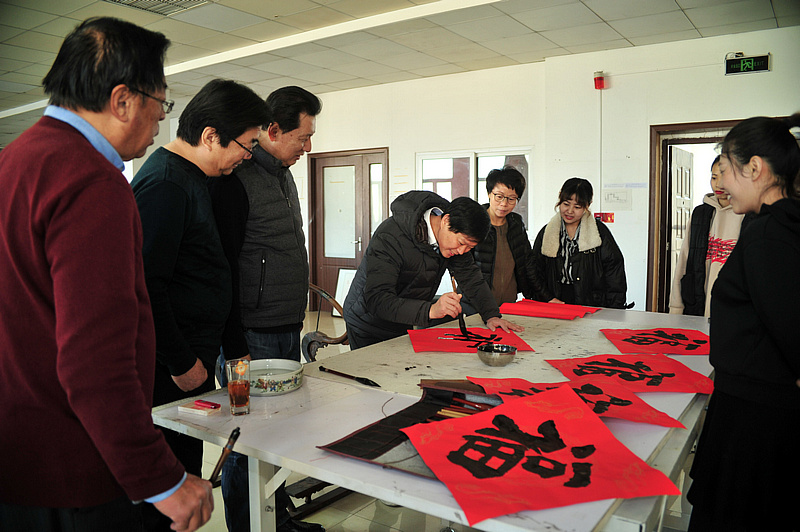 陈旺生董事长与艺术家们在活动现场写福字。