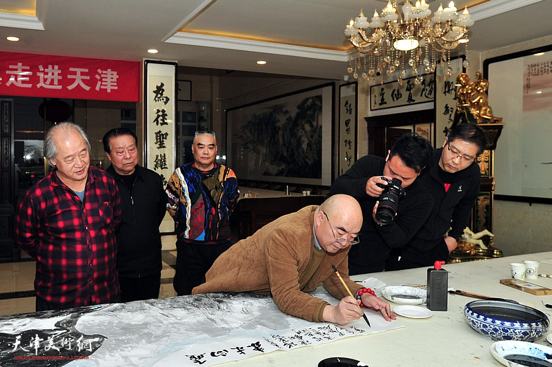 “为奥运喝彩”项目“百名画家绘冬奥”走进天津记者现场采访尹沧海作画。