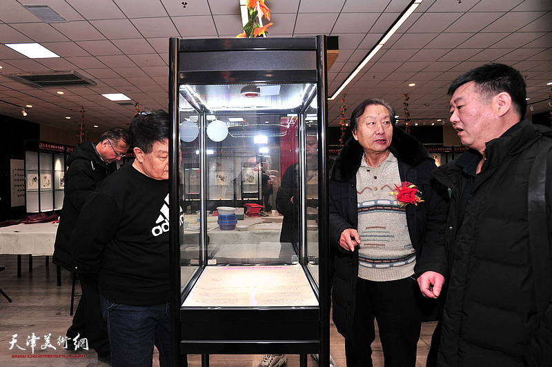 刘家城、刘经章在画展现场观赏展品。