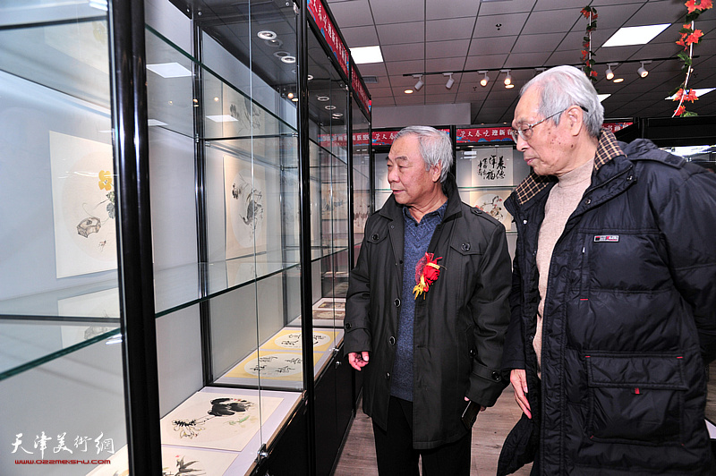 黄枕石、王大奇在画展现场观赏展品。
