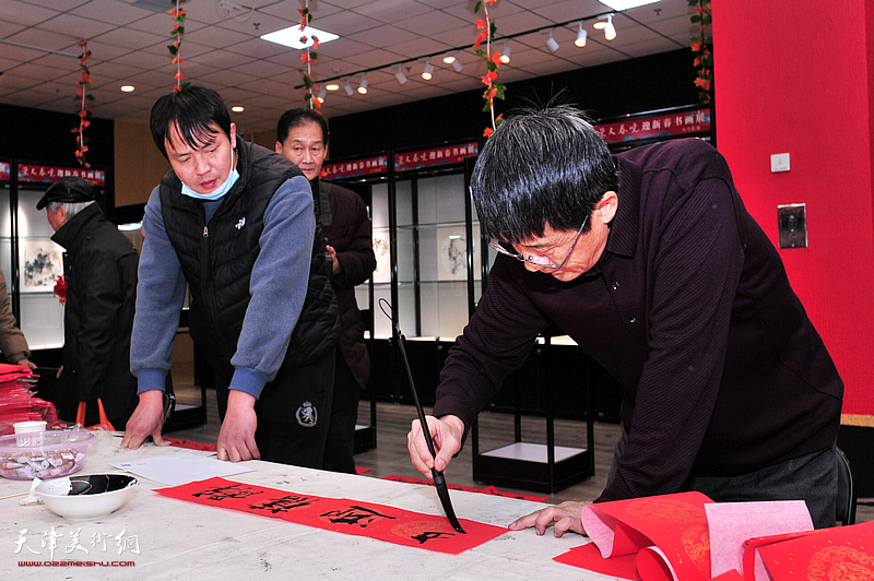 袁强民在画展现场写福字。