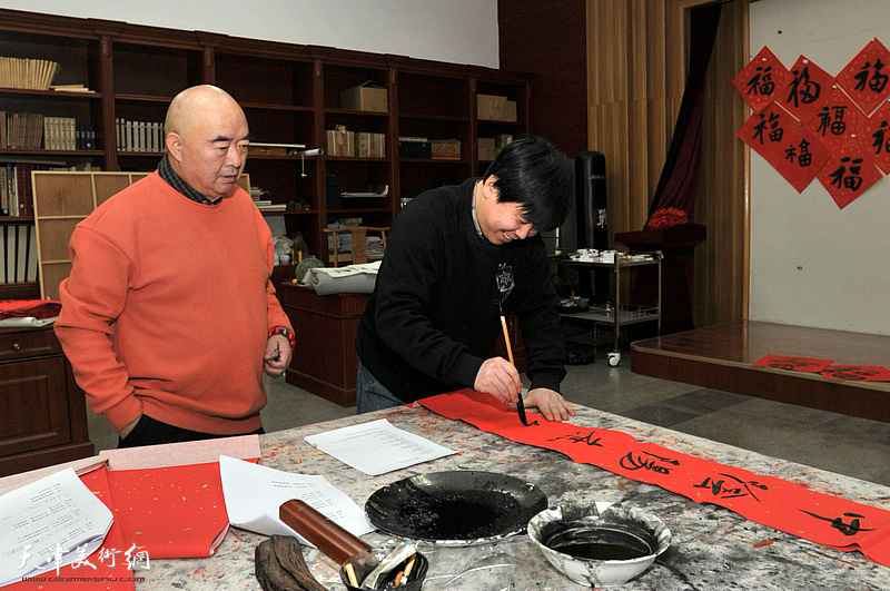 陈志峰老师在创作活动现场书写春联。
