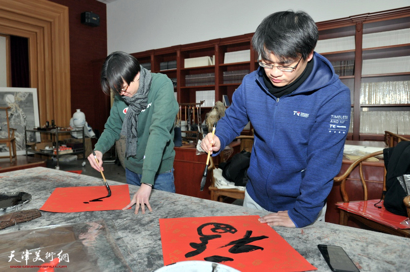 蔡志伟、孙赟路在创作活动现场写福字。