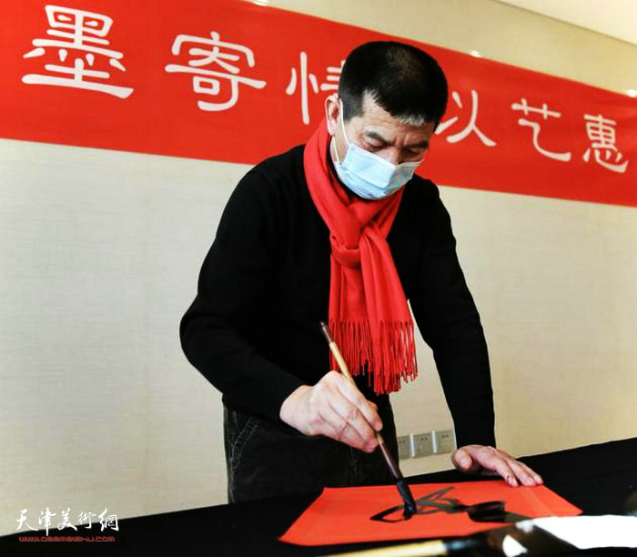 天津画院院长范扬在活动中写福字。