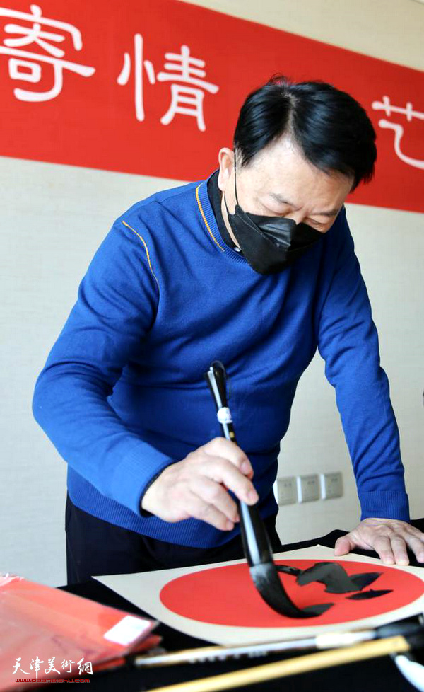 天津画院特聘终身画家华绍栋在活动上写福字。