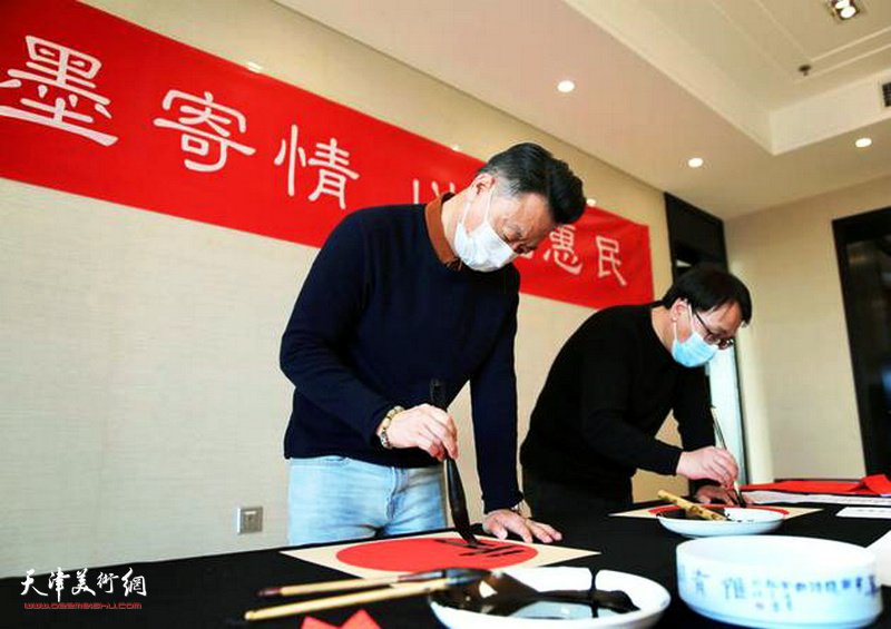 左起：李旺、张晓彦在活动中写福字。