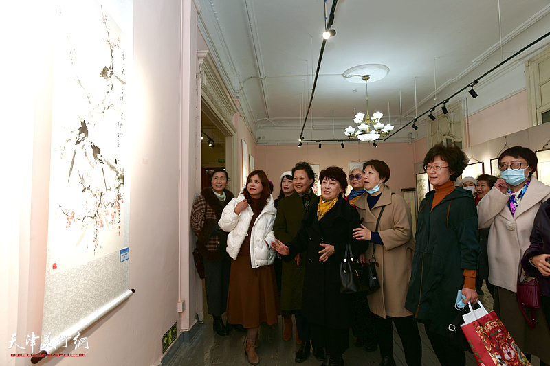 梦玉与女书画家们观赏展出的作品。