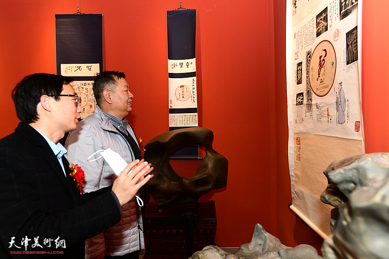 李传凤向李林河介绍展出的“茶档心画—刘栋茶纸书法”。