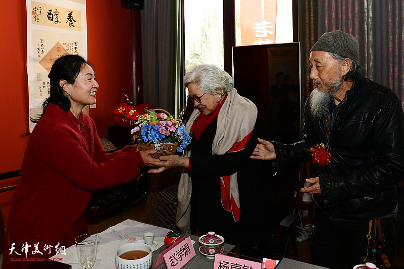 赵学娟向刘栋、杨惠敏夫妇献花，祝贺展览举办成功。