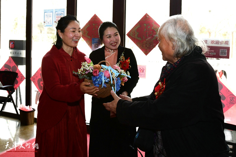 赵学娟、翟智慧向逯彤先生献花，祝贺展览举办成功。