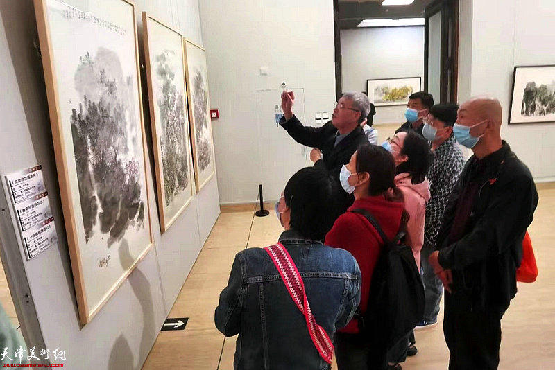申世辉教授在画展现场向观众介绍展出的山水画作品