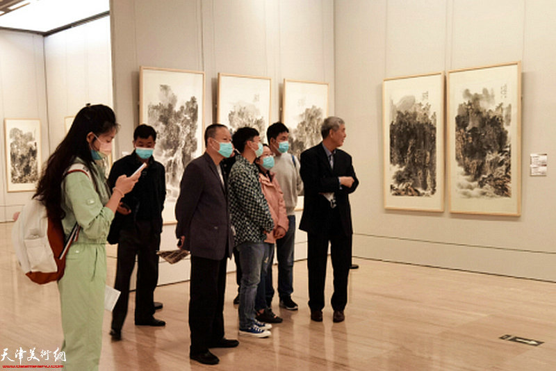 申世辉教授在画展现场向观众介绍展出的山水画作品