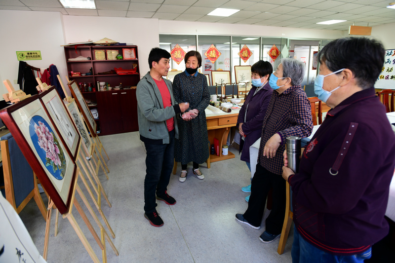 著名花鸟画家王群英在航天城社区与书画爱好者交流。