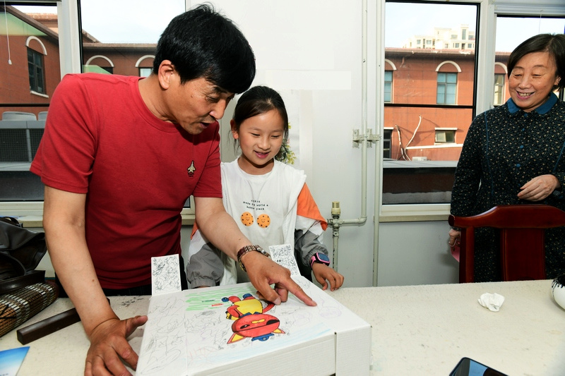著名花鸟画家王群英在航天城社区为小学员辅导作品。