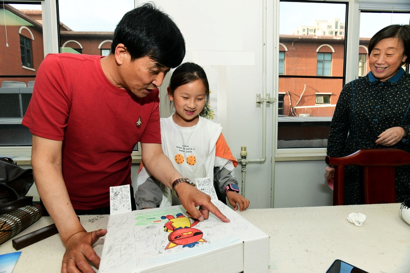 著名花鸟画家王群英在航天城社区为小学员辅导作品。