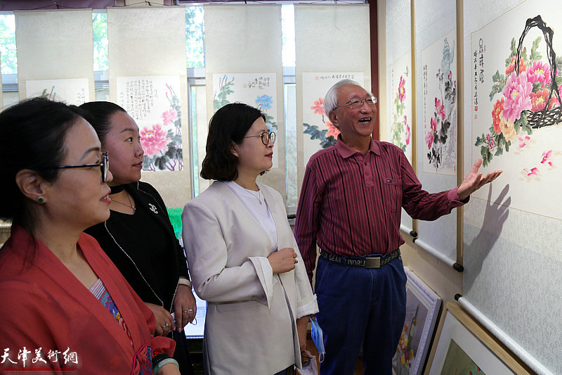 崔长青向伊梦茹、郭其君介绍展出的作品。