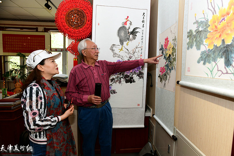崔长青向来宾介绍展出的作品。