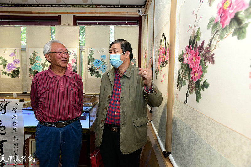 崔长青与陈元龙观赏展出的作品。