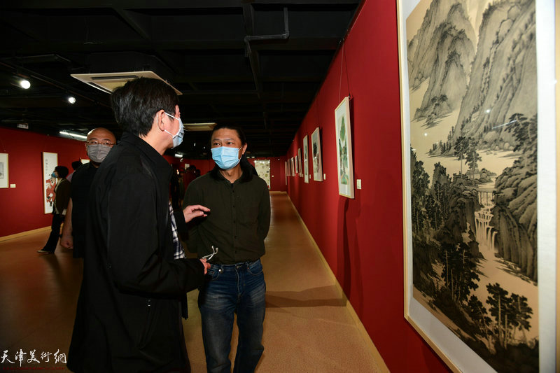 姚铸、沈宪民观赏展出的画作。