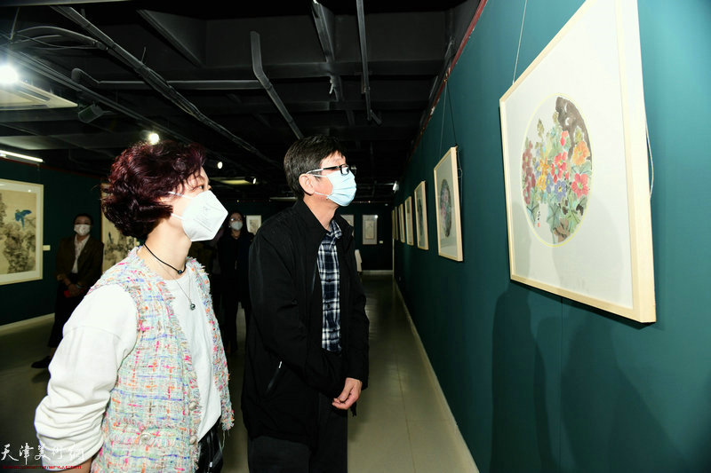 朱珊与沈宪民观赏展出的画作。